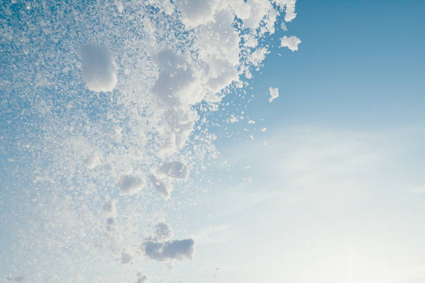 istock snow splash in the air, blue sky background 1304111493