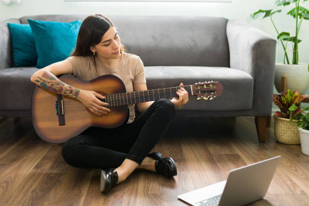 взрослая женщина в возрасте 20 лет учится играть на акустической гитаре - 20s acoustic guitar adult attractive female стоковые фото и изображения