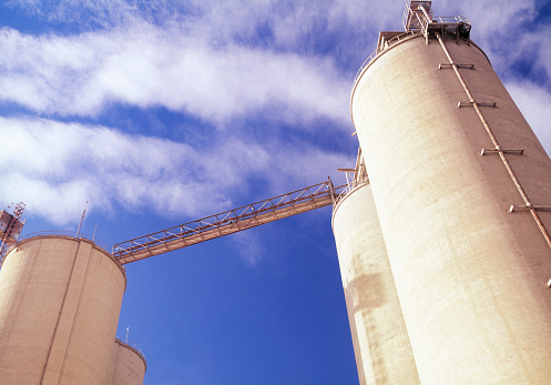 Agricultural silos, storage and drying of grains, wheat, corn, soy, sunflower against the blue sky background, grain dryer