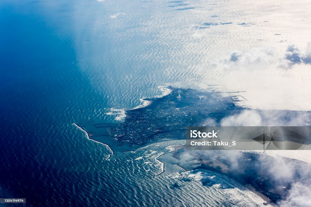 white cloulds and sea from window of airplane Aerial View Stock Photo