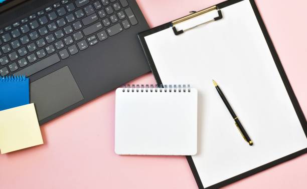 istock Clipboard on laptop, notepad on pink background. Workplace. copy space, flat lay. Concept business and finance. 1304124782