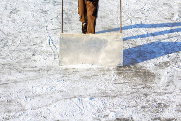 istock Cleaning snow with shovel on ice rink. 1304125962