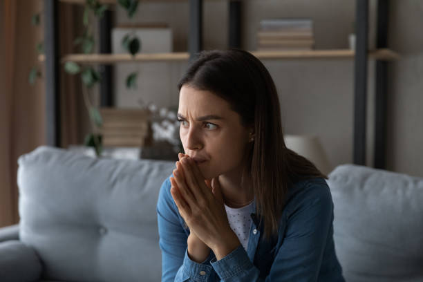 istock Worried young woman feel fear lean forward with folded hands 1304127547