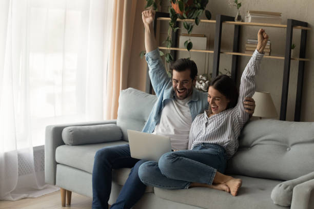 istock Shocked couple cuddle scream wow reading email with great news 1304127568