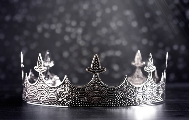 istock A Silver Metal King or Queens Crown on a black Wood Table 1304128998