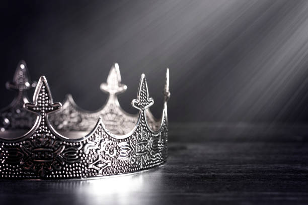 istock A Silver Metal King or Queens Crown on a black Wood Table 1304129059