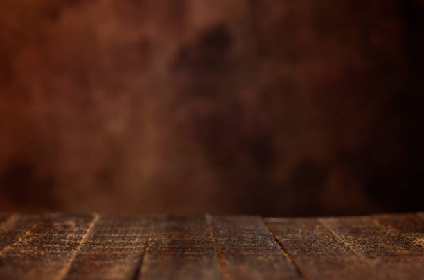 istock Simple Brown Wood Table with a Blank Brown Background 1304129074