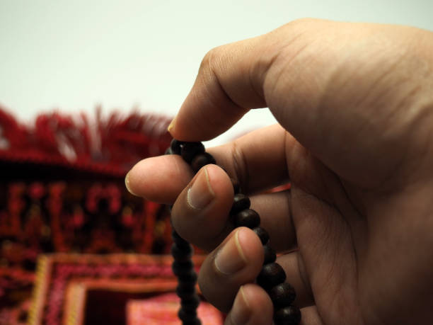 istock Moslem man praying using wooden beads on a praying rug 1304134118
