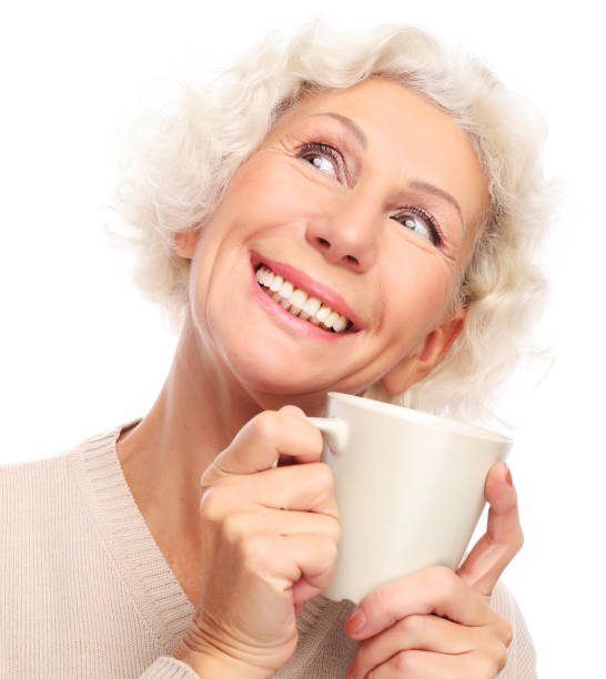 old excited lady smiling laughing, holding cup drinking coffee or tea