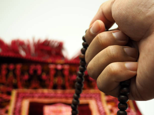 istock Moslem man praying using wooden beads on a praying rug 1304134138