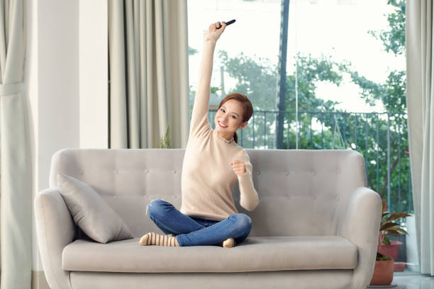 istock Ecstatic positive girl student sit divan legs barefoot crossed hold channel remote control watch final league championship foot ball game celebrate national team in house indoors 1304134214