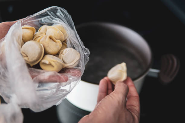 dumplings from dough with meat are boiled in boiling water. food photo. the culinary dish ukrainian dumplings. - intermediate imagens e fotografias de stock