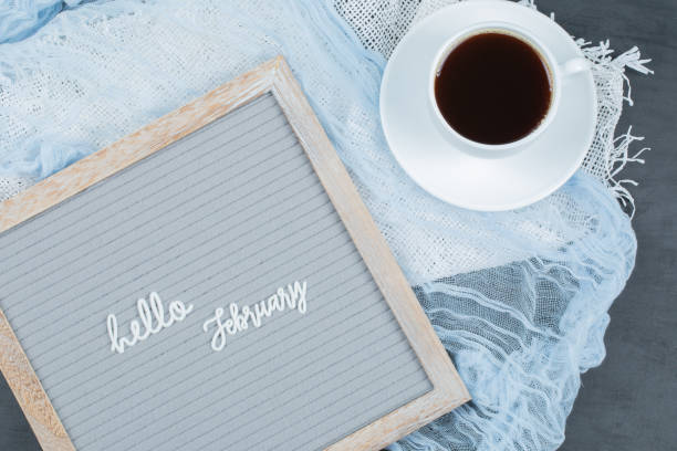 istock Hello february poster embedded on grey background with a cup of drink aside 1304141406