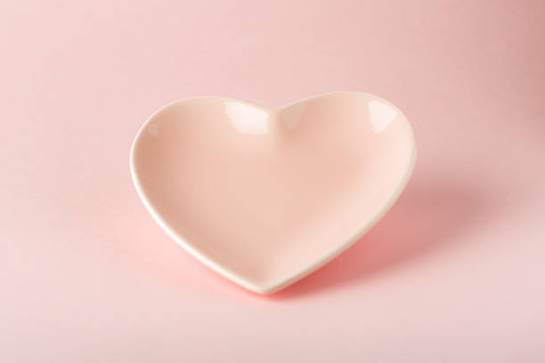 istock Empty pink plate in the shape of a heart on a pink background 1304143203