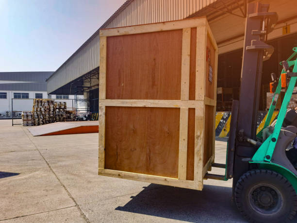 istock Worker driving forklift loading shipment carton boxes goods on wooden pallet at loading dock from container truck to warehouse cargo storage in freight logistics, transportation industrial, delivery 1304145617