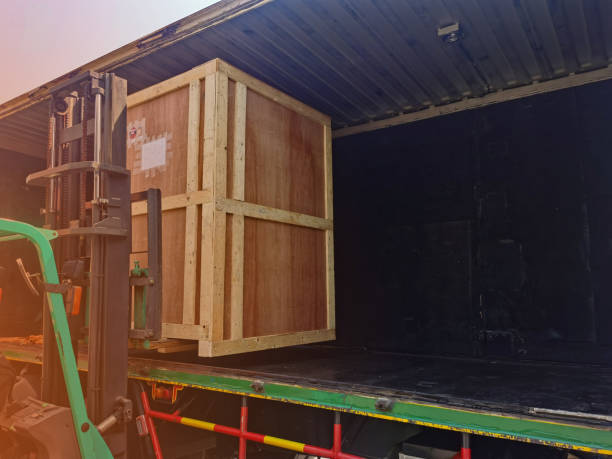 istock Worker driving forklift loading shipment carton boxes goods on wooden pallet at loading dock from container truck to warehouse cargo storage in freight logistics, transportation industrial, delivery 1304145631
