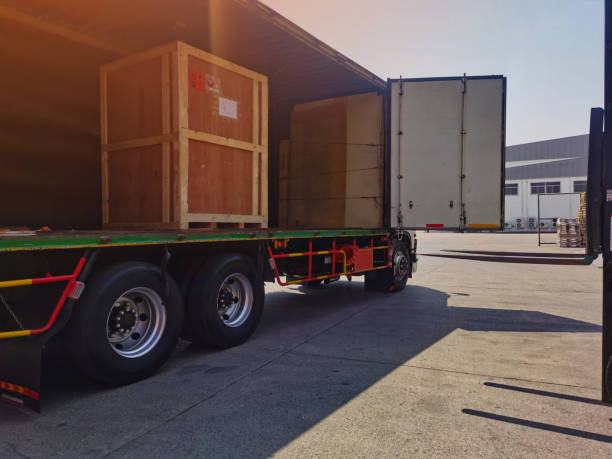 istock Worker driving forklift loading shipment carton boxes goods on wooden pallet at loading dock from container truck to warehouse cargo storage in freight logistics, transportation industrial, delivery 1304145633