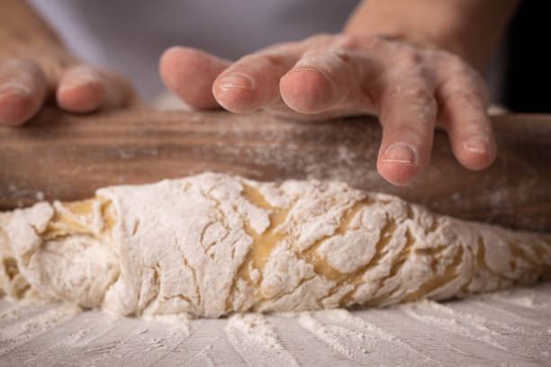 istock Woman baker rolls out dough at the bakery. close up 1304147048