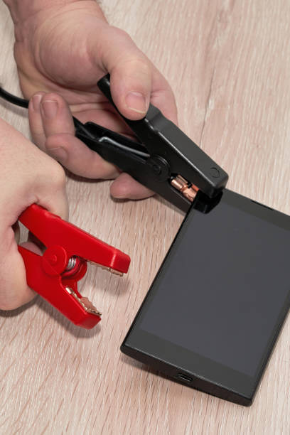istock Hands connect crocodile clips to the smartphone body 1304148296