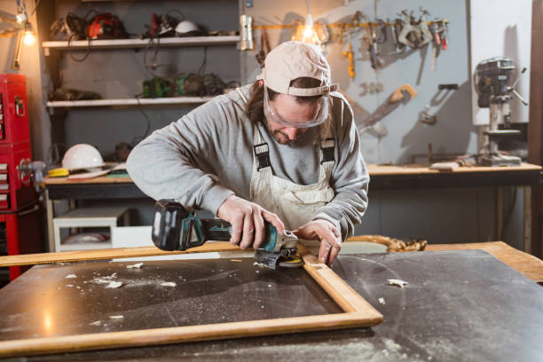 istock Male carpenter working on old wood in a retro vintage workshop. 1304149951