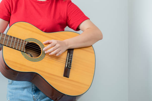 istock Man holding a wooden guitar and playing 1304152682