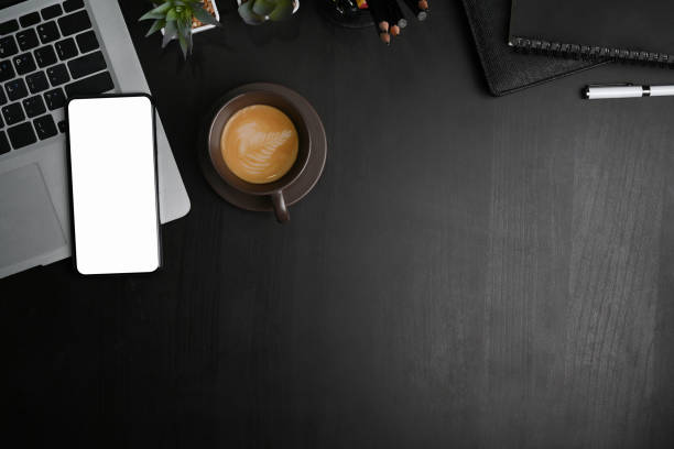 istock Top view of smart phone, laptop computer and copy space on black leather. 1304153887