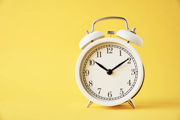 istock White vintage alarm clock on a yellow background with copy space 1304156087