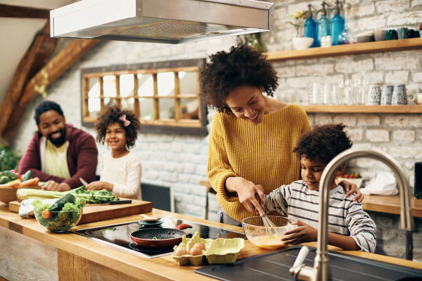 istock Happy African American mother and son preparing scrambled eggs in the kitchen. 1304156251