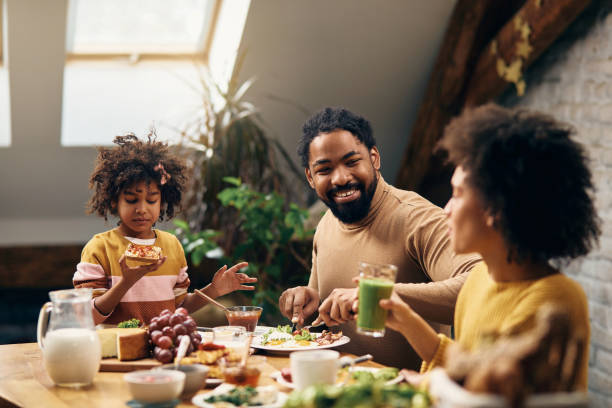 istock Happy black family talking while having breakfast at home. 1304156276
