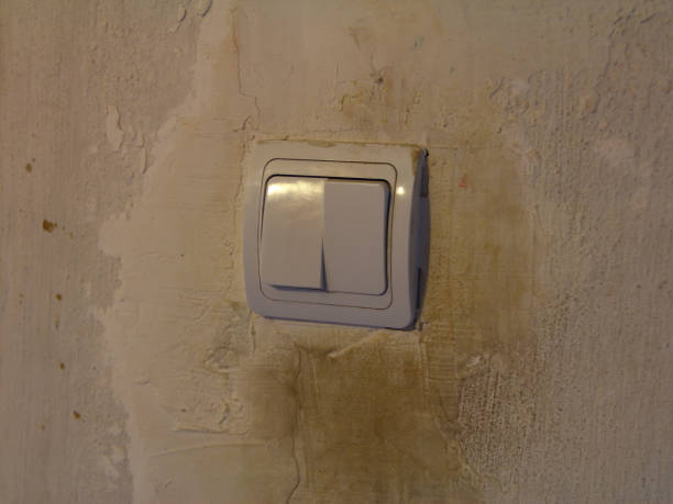 istock Dirty white light switch with dirty handprints on dirty white wall background 1304161443