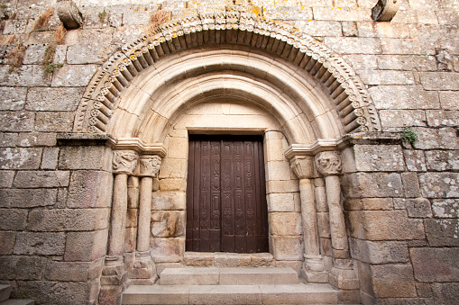 Ancient Santiago romanesque church ( XII century) front door, facade decorated entrance in Allariz old town, Ourense province, Galicia, Spain.