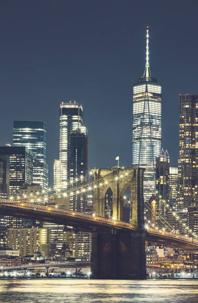 brooklyn bridge e manhattan à noite, imagem colorida tonificada, nova york, eua. - photography urban scene vertical toned image - fotografias e filmes do acervo