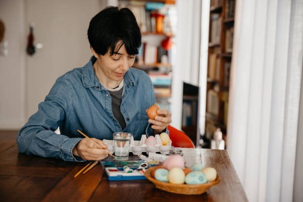 istock Woman painting Easter eggs at home 1304165732