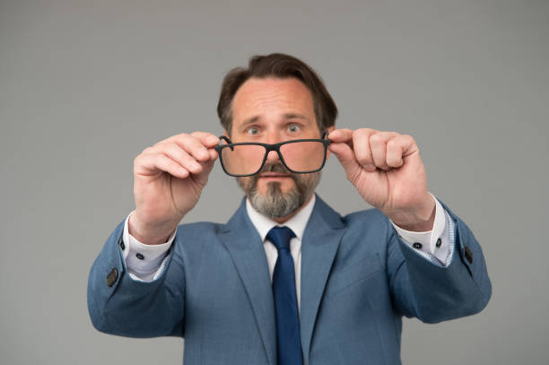 istock Man hold eyeglasses blurred glass bring closer, eyesight problems concept 1304169301
