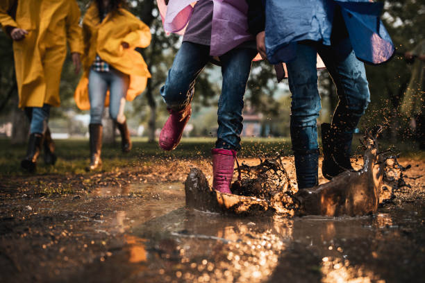istock Unrecognizable kids running through muddy puddle in nature. 1304173298