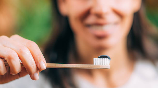 istock Toothpaste with Black Charcoal on Wooden Toothbrush. 1304173517
