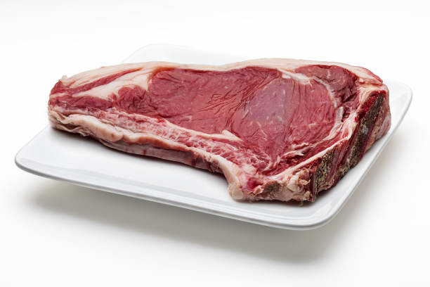 istock Raw red beef cutlet (beef, heifer, veal) on a plate. Isolated on white background. 1304175495