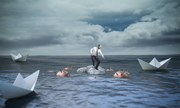 man on a rock waiting for help from boats but surrounded by explosive mines