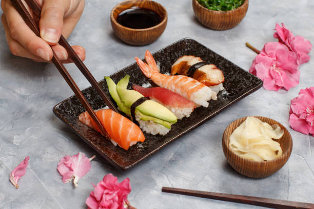 istock Close up of hand taking roll with chopsticks from a plate 1304177184