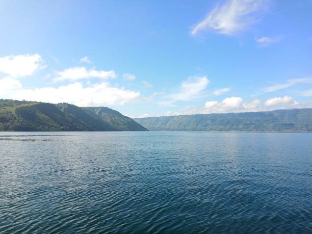 istock Beautiful lake and hill landscape with dramatic wave, blue sky and clouds 1304179850
