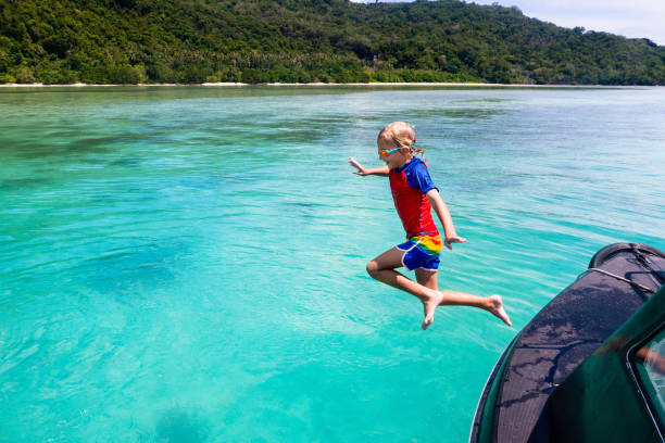 dziecko skacze do wody morskiej. wakacje jachtowe. - clear sky water sports and fitness yacht zdjęcia i obrazy z banku zdjęć