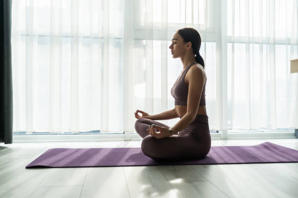 istock Sport application, website. Cheerful young woman practicing yoga at home, using laptop, copy space 1304182405