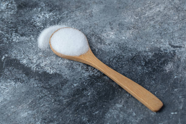 istock Salt in a wooden spoon on a marble background 1304182970