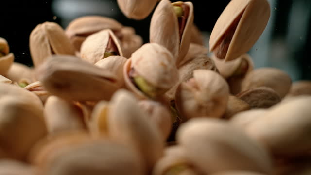 SLO MO LD Pistachios falling and forming a pile