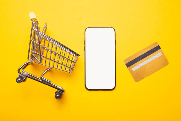 istock Small shopping trolley  credit card and smartphone with blank screen for copyspace 1304184977