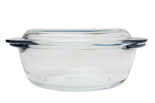 Round-shaped glass casserole with handles. Isolated on a white background, side view close-up