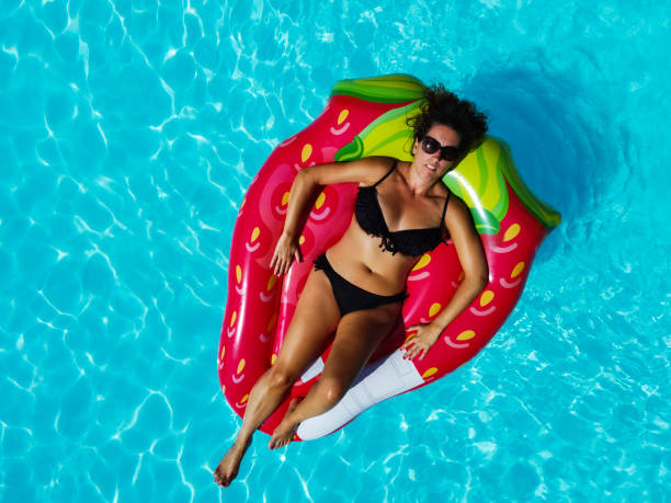 istock Woman floating on an ait mattress in a pool 1304190262