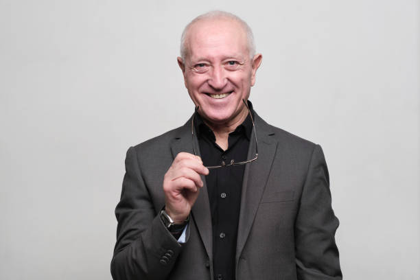 istock Senior man wearing a suit and holding his eyeglasses. 1304190805