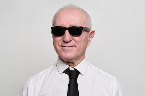 Senior man studio portrait
Senior man with sunglasses and a necktie