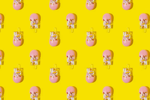istock Creative pattern with popsicle ice cream filled with various pills and tablets on bright yellow background 1304191679